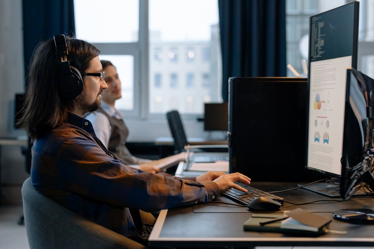 services-01 Two programmers working together with focus on coding in a modern, tech-savvy office environment.