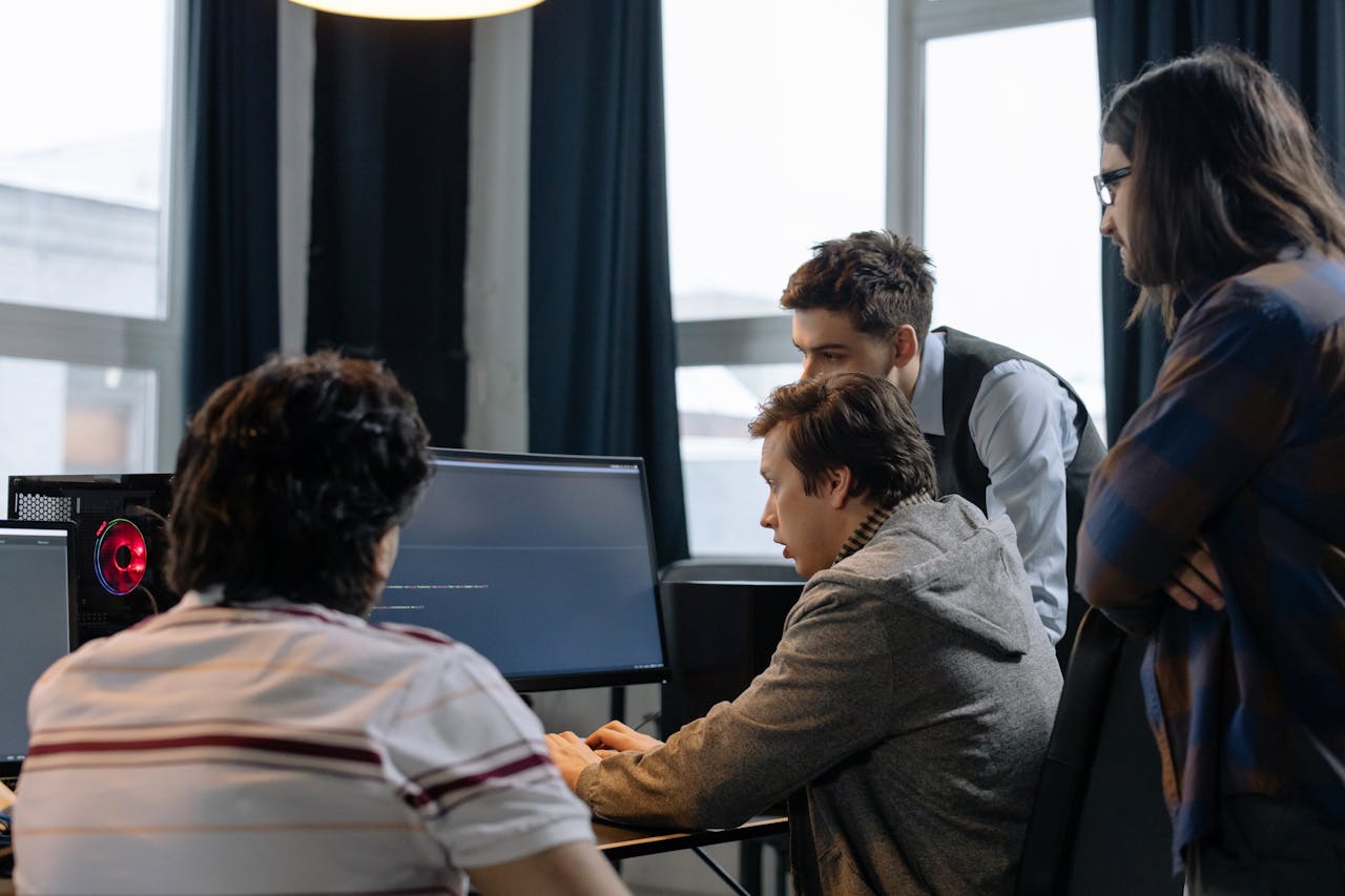 services-02 Group of developers working together on a computer programming project indoors.