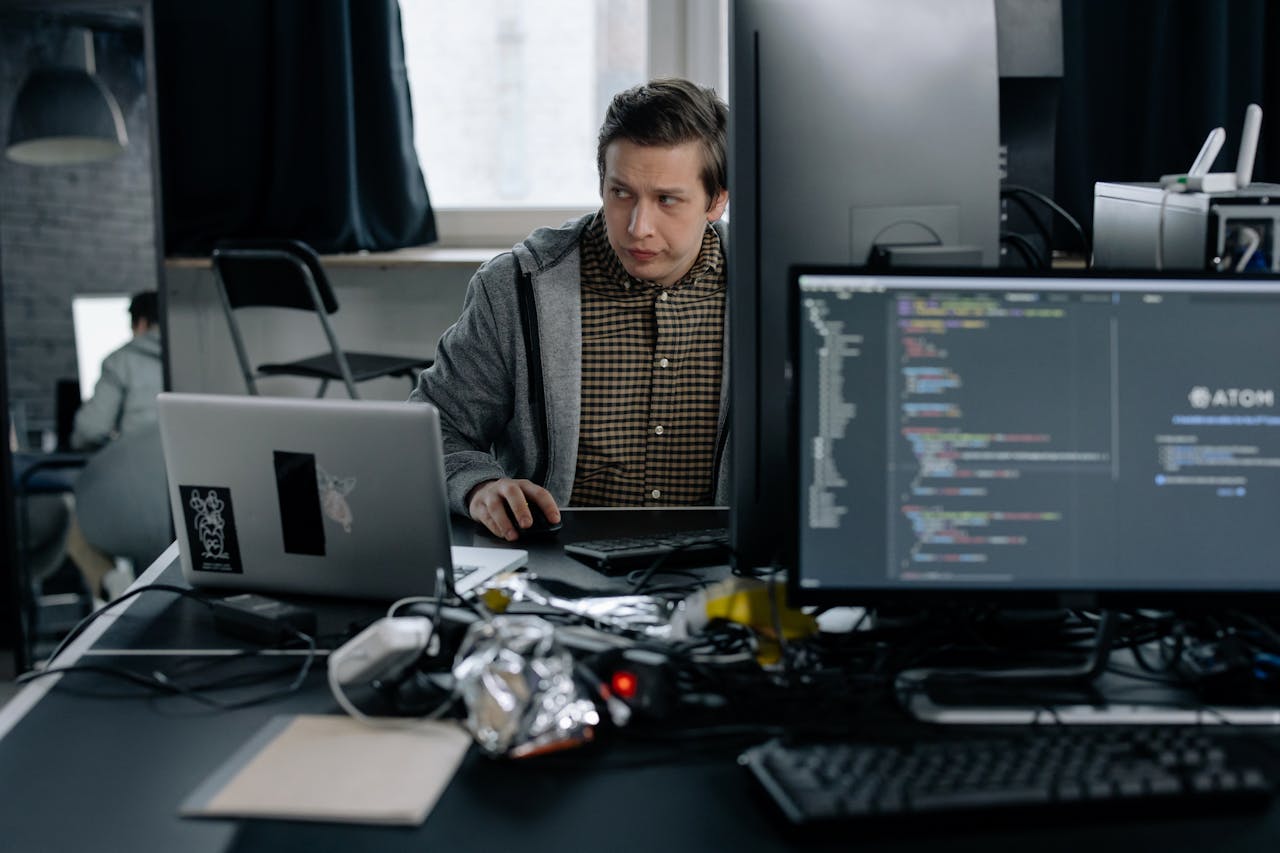 why-choose-us A programmer in a modern office working on computer code, showcasing a focused work environment.